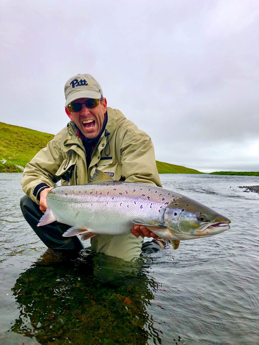A fisher holding a large Atlantic Salmon.