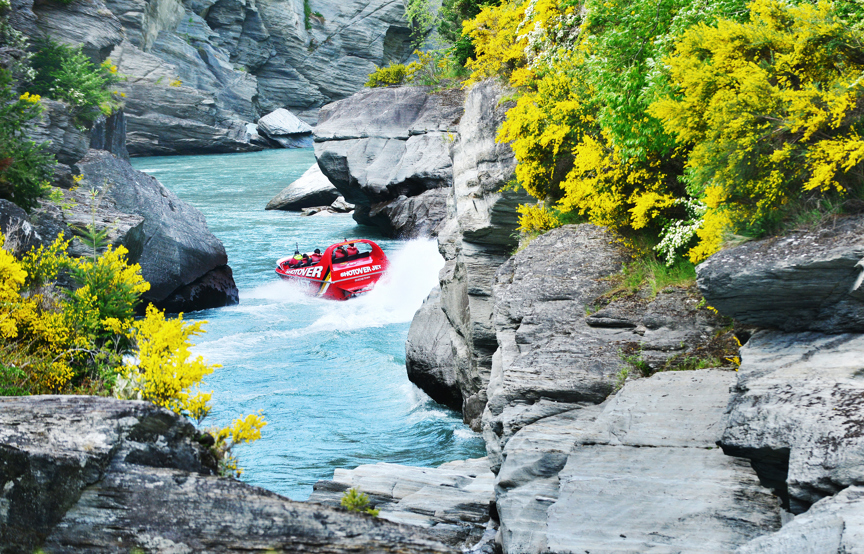 Jet boat in river between rocks