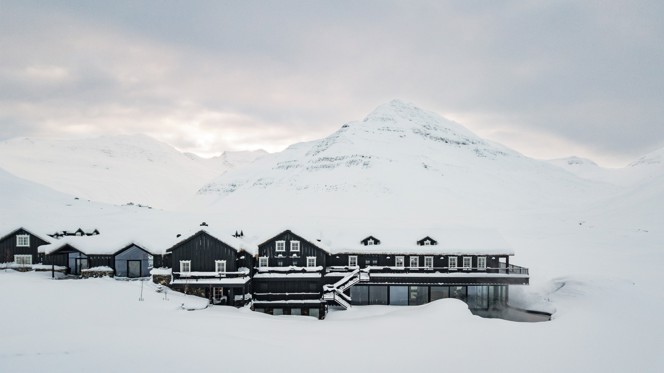 An aerial view of Deplar Farm in a snow covered mountain valley.