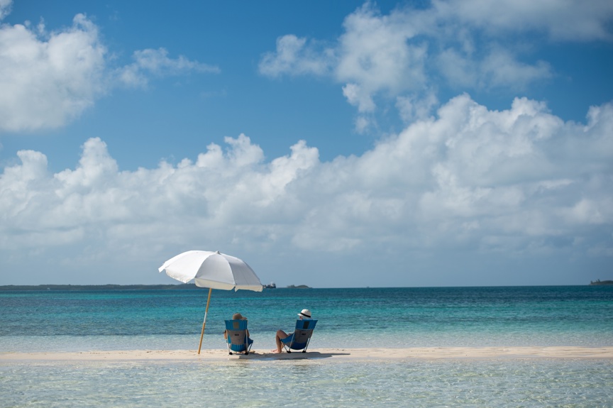 A couple relaxes on a beach in the Bahamas.
