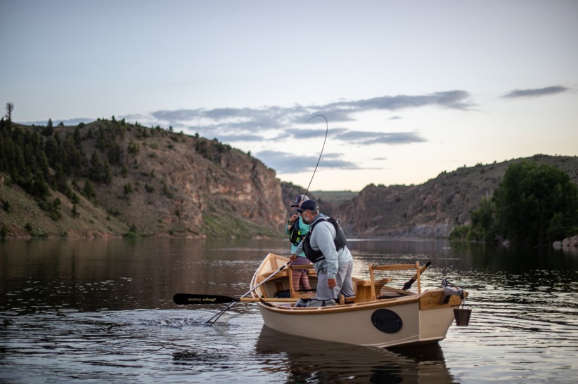 Angler fights a fish from a boat on the Gunnison River.