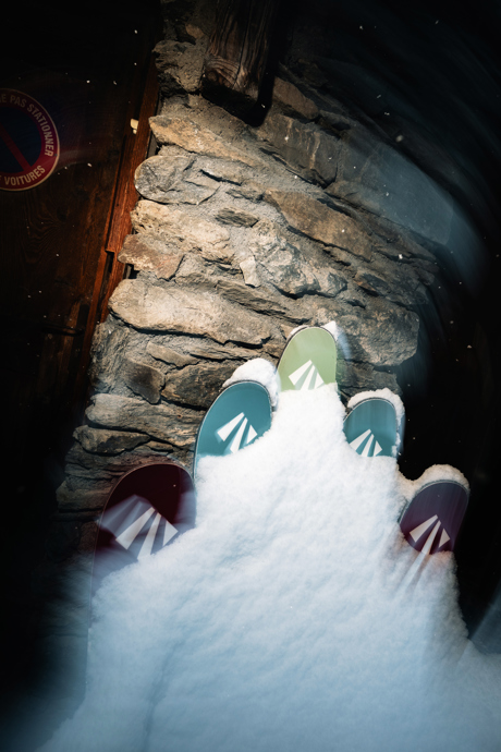 Several pairs of skis up against a lodge in the French Alps