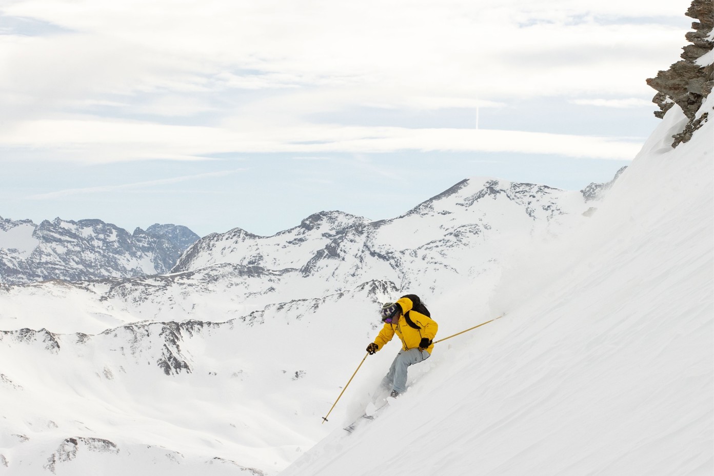 Man skiing down a steep mountain side.