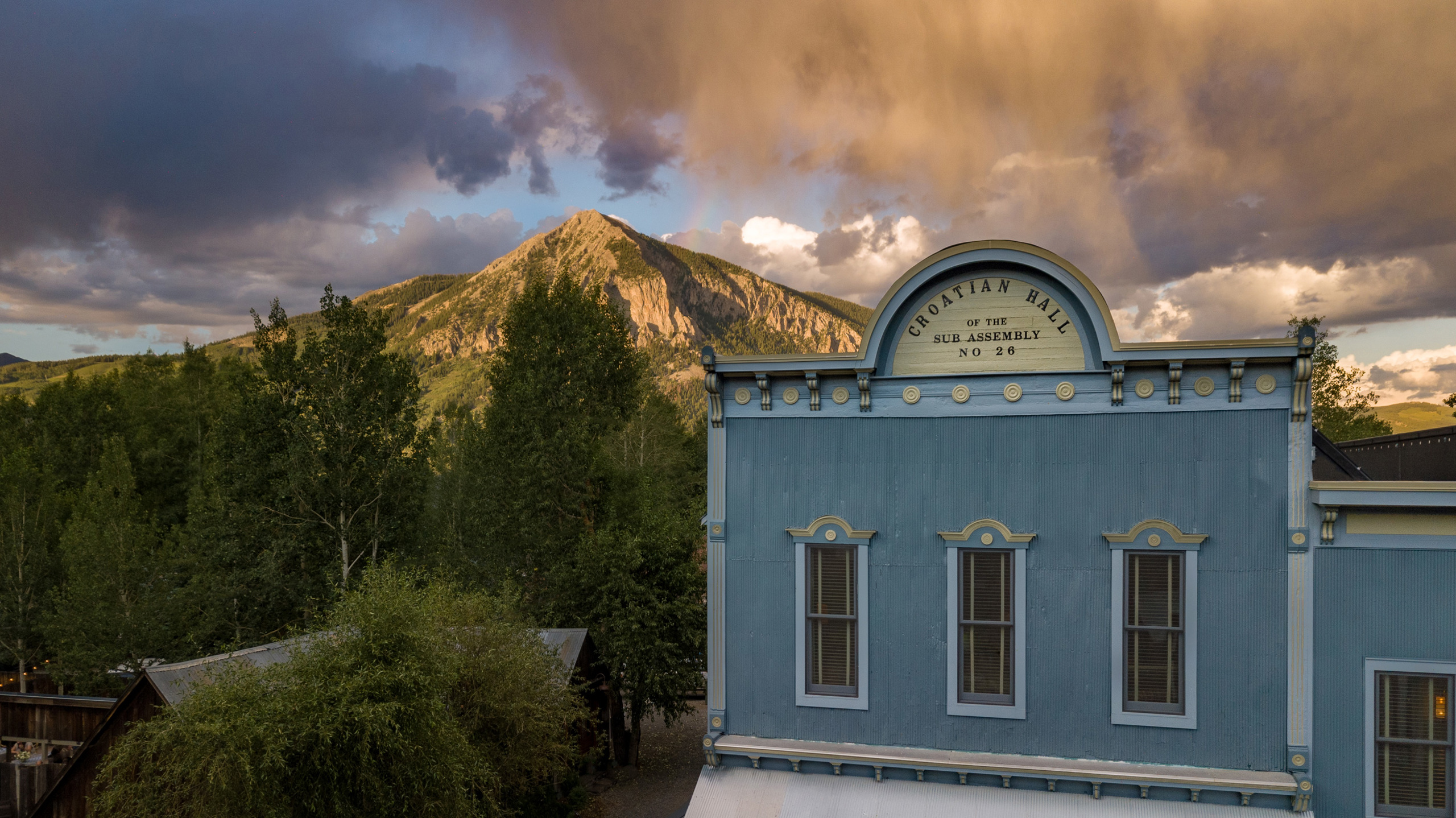 The top portion of the Old Croation Saloon, now Scarp Ridge Lodge on a summer day, with a mountain a
