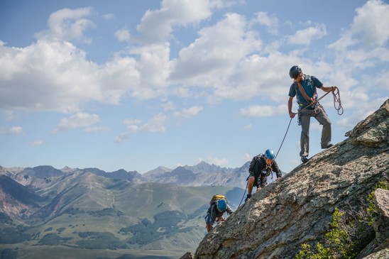 A group of climbers going up a ridge with a guide in the Rockies.