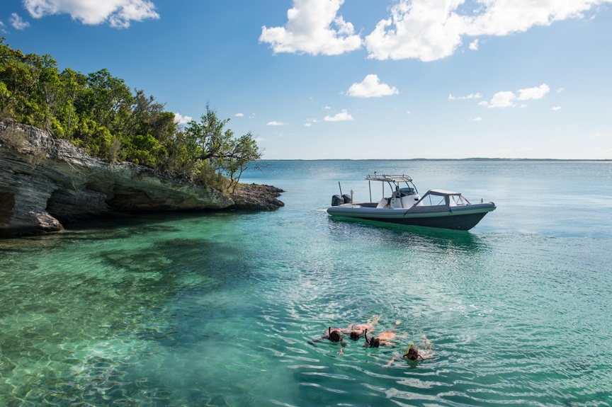Four snorkelers explore a Bahamian cove.